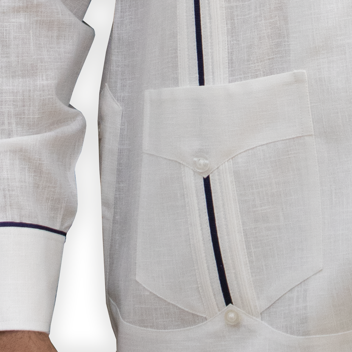 Close-up of blue trim details on white guayabera fabric