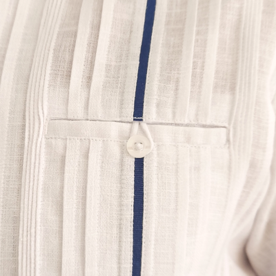 Close-up of navy blue trim on luxury white long-sleeve wedding guayabera