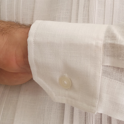 Close-up of red trim details on elegant white guayabera