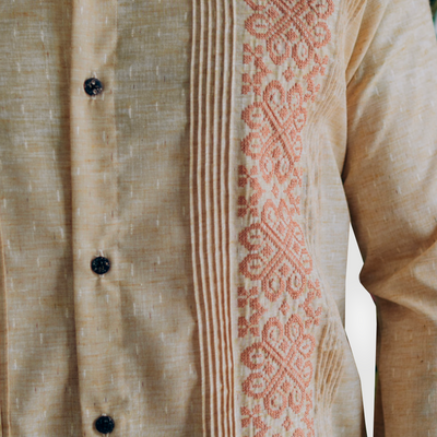 Close-up of traditional cross-stitch embroidery on beige guayabera