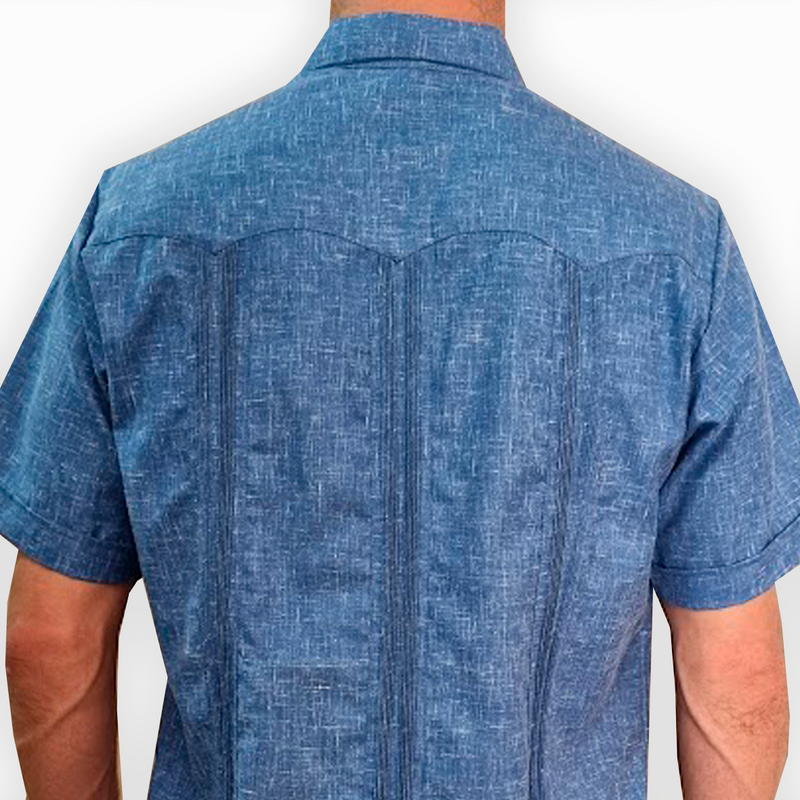 Hombre con guayabera azul denim combinada con pantalón casual


