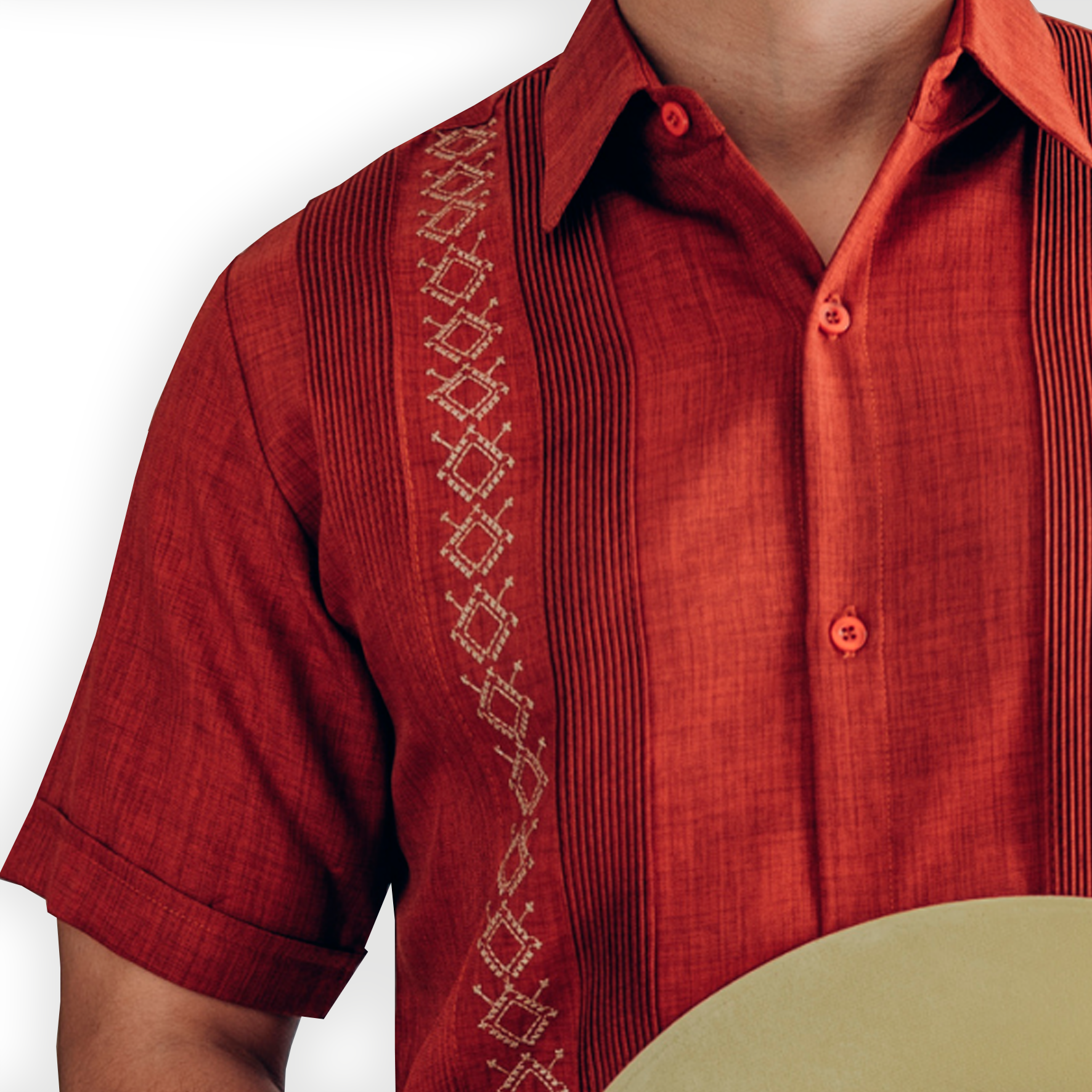 Handcrafted embroidery detail on burnt orange guayabera shirt