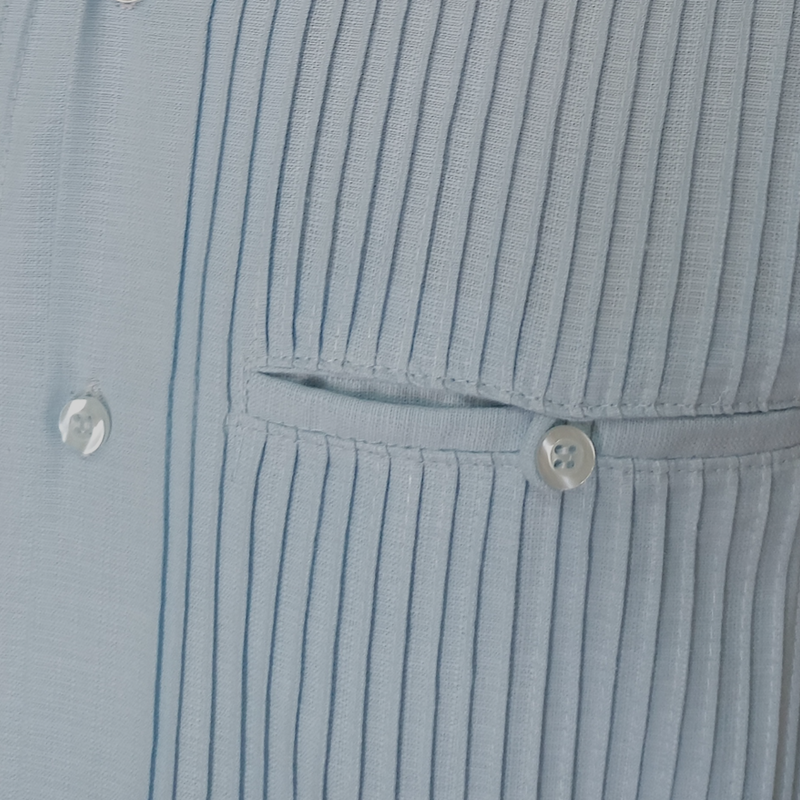 Man wearing light blue short sleeve guayabera with beige shorts