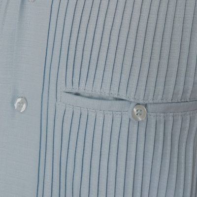 Man wearing light blue short sleeve guayabera with beige shorts