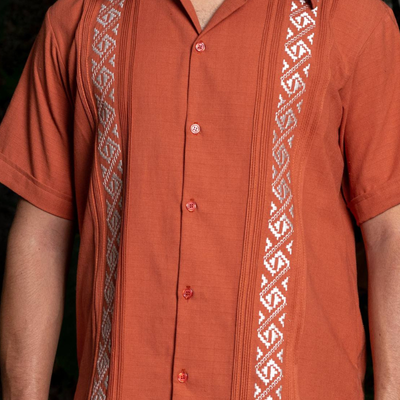 White hand embroidery detail on burnt orange guayabera shirt