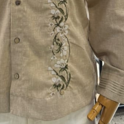 close-up of floral embroidery on beige guayabera