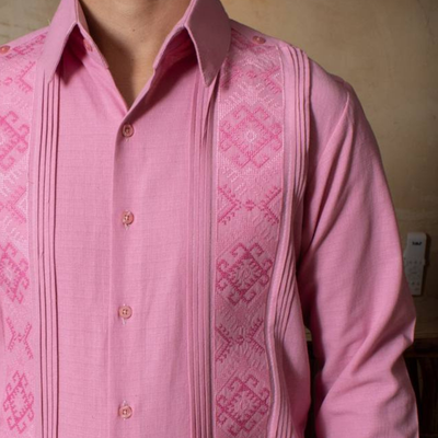 close-up of handmade embroidery on pastel pink guayabera
